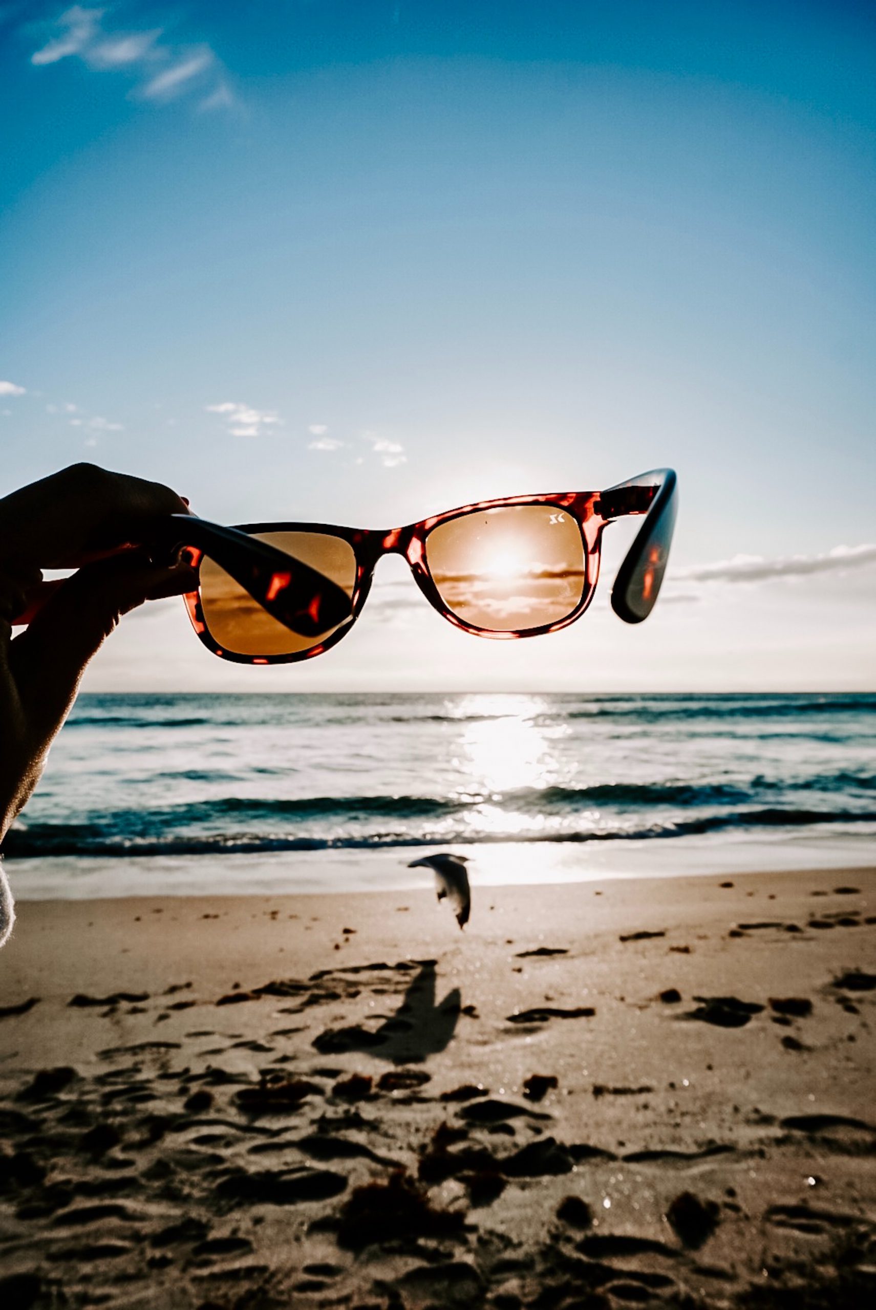Okulary przeciwsłoneczne zasłaniające słońce na plaży 